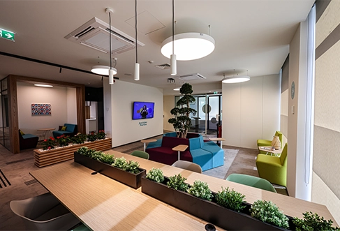 A colorful working and meeting space, with plants and seating areas. (photo)