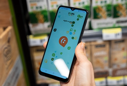 A person holding up a smart phone showing a coupon app. (photo)
