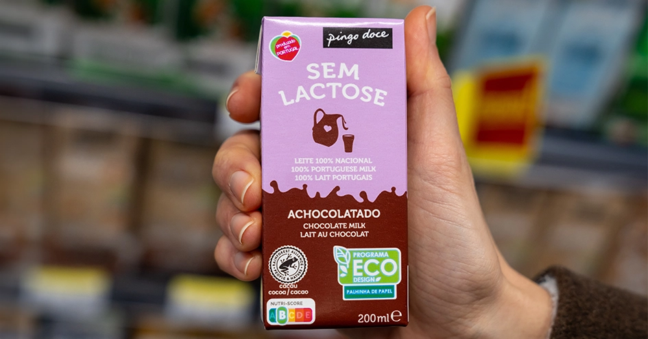 Close-up of a hand holding a lactose-free chocolate milk (photo)