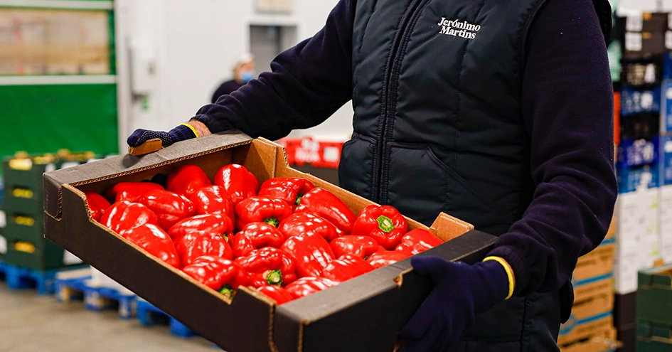 Employee holding a crate of red peppers (photo)