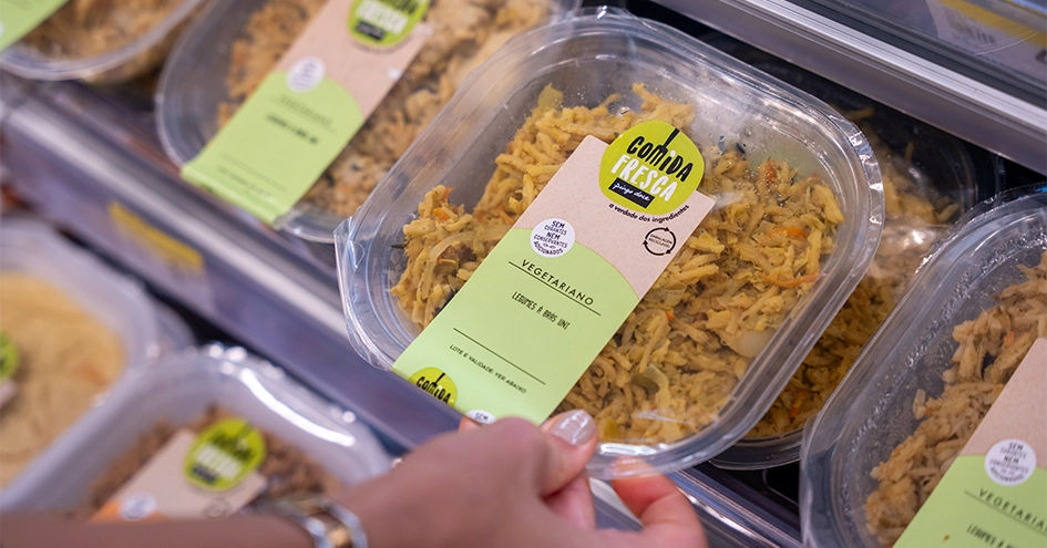 Person taking a vegetarian takeaway meal from the shelf (photo)