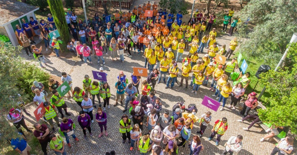 A group of people wearing colorful clothes and holding colorful sign with different icons photographed from above