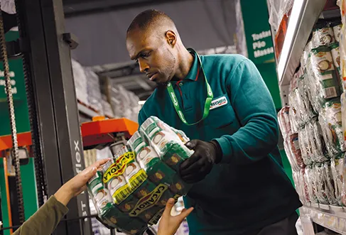 An employee at Recheio handing a product to a colleague (photo)