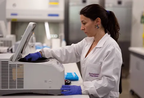 An employee operating some laboratory equipment in a lab (photo)