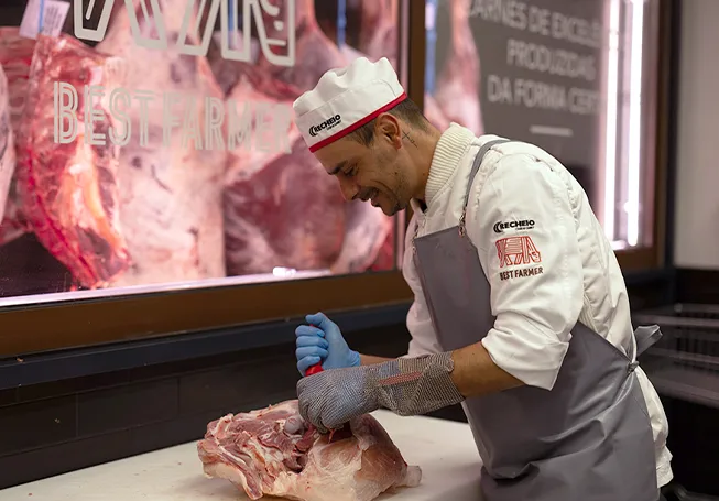 A Recheio employee butchering a fresh pice of meat at the Best Farmer counter (photo)