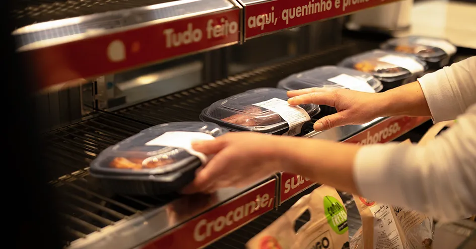 Close-up of someone restocking ready-to-go hot food (photo)
