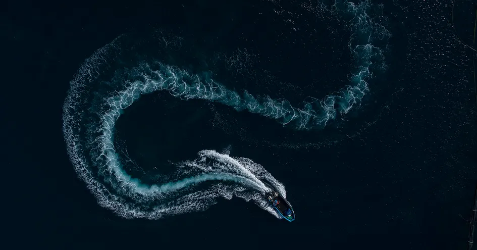 Aerial view of a boat driving in curves (photo)