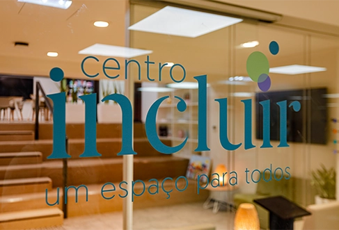 Uma porta de vidro com o logótipo do “Centro Incluir”. (foto)