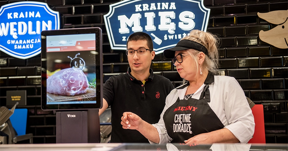 Dois colaboradores a trabalhar na caixa registadora atrás do balcão de charcutaria (foto)