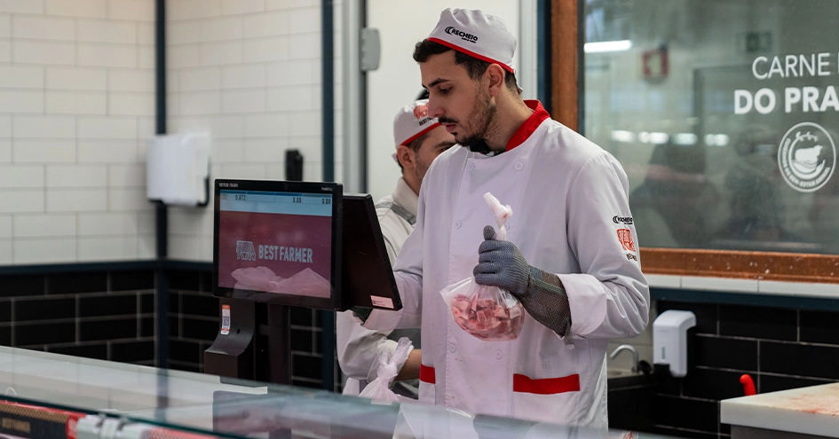 Um talhante a trabalhar ao balcão, pesando o produto (foto)
