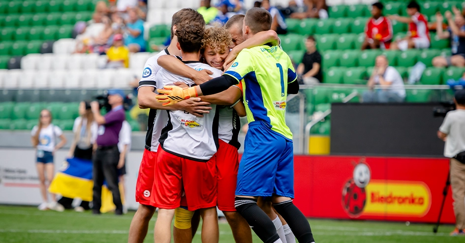 Jogadores de futebol abraçados num campo de futebol (foto)