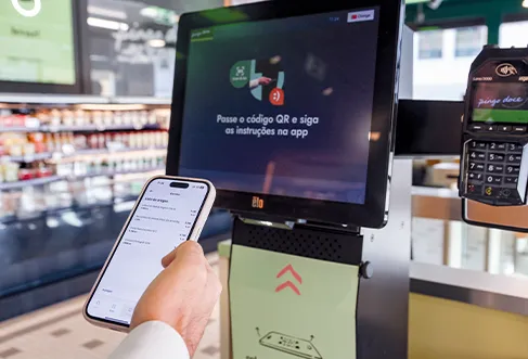 Um cliente a utilizar uma aplicação móvel no balcão de pagamento automático (foto)