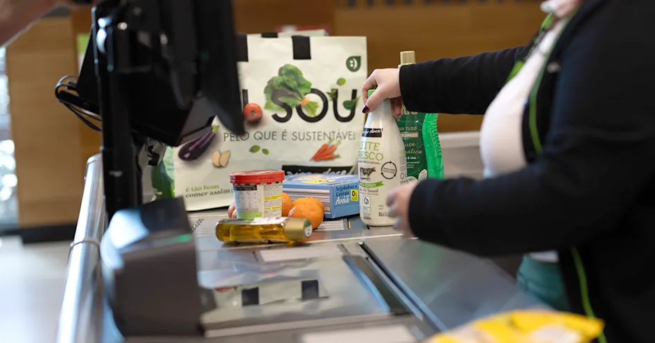 Um colaborador numa caixa de pagamento a fazer scan de alguns produtos (foto)