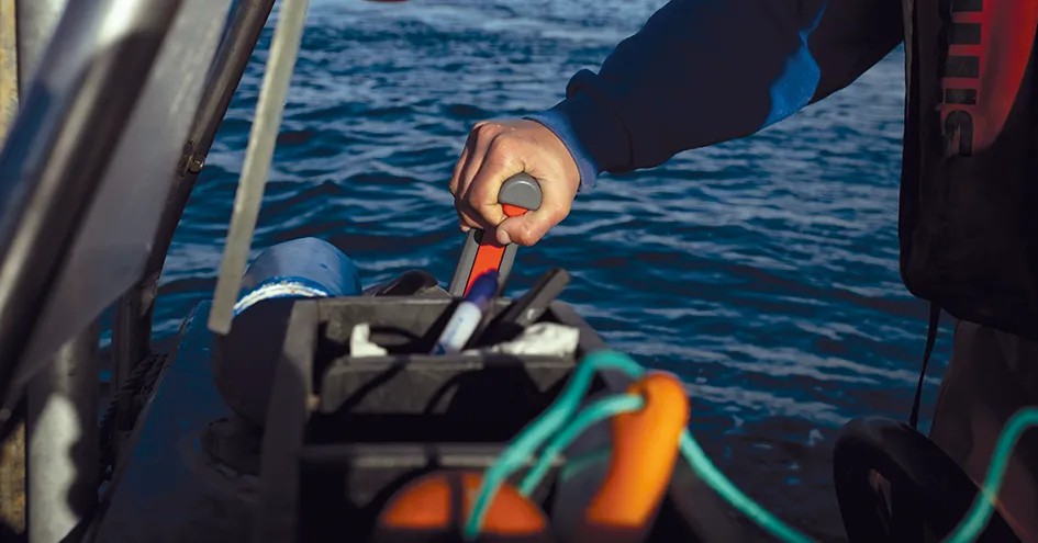 Plano fechado de uma pessoa a conduzir um barco (foto)