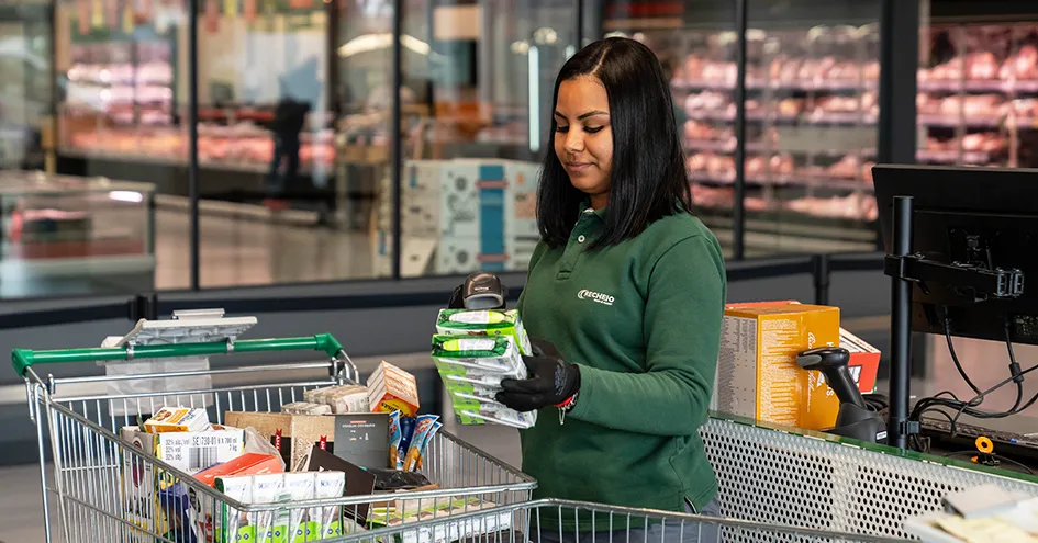Um colaborador do Recheio a digitalizar artigos diretamente de um carrinho de compras na caixa (foto)